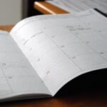 open monthly planner on wooden desk