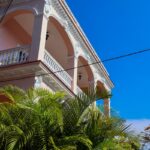 Pretty pink building with a balcony and clear sky.