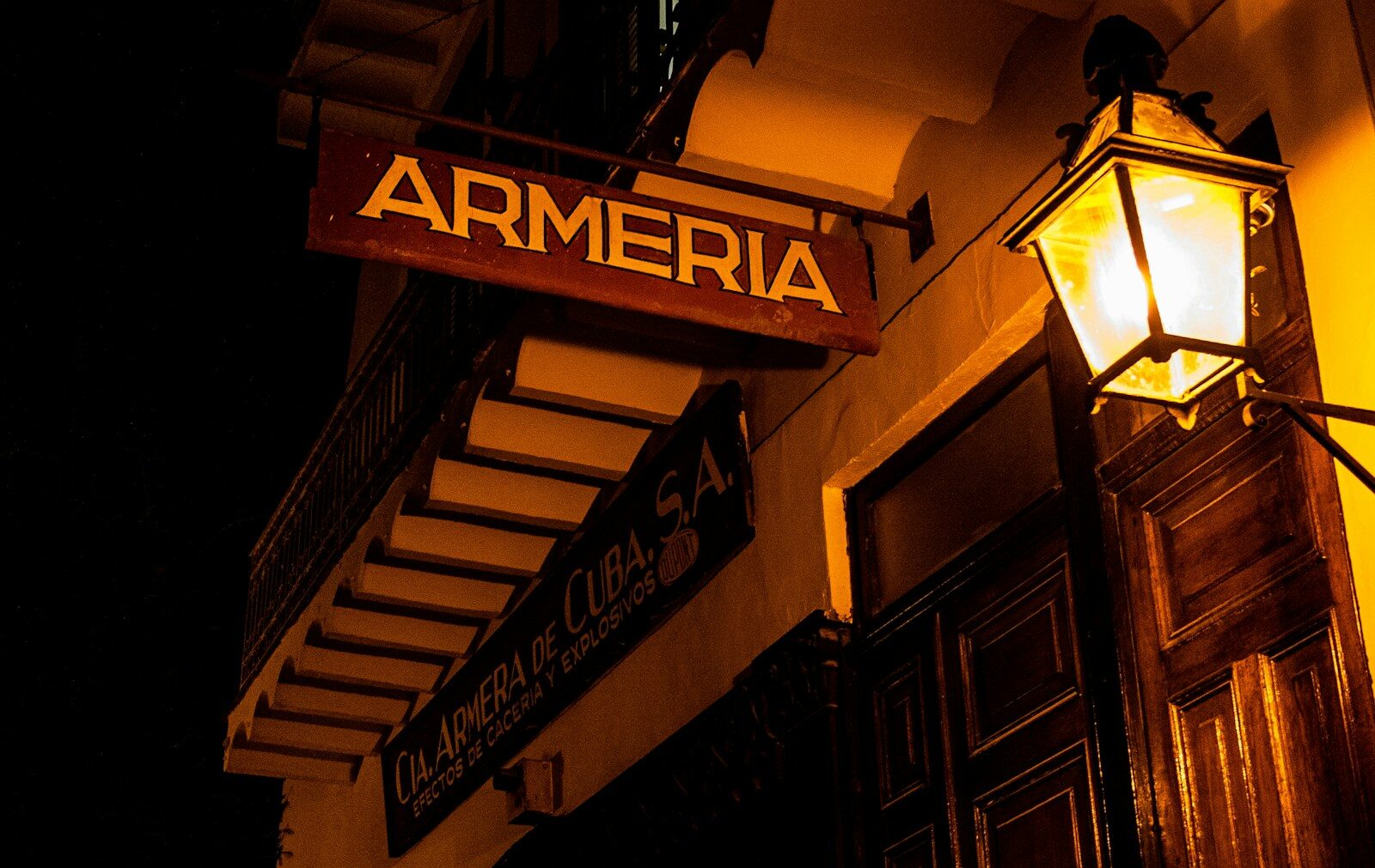 A store sign reads "armeria" lit by a lantern.