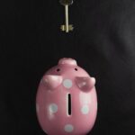 a pink piggy bank with a key hanging from it